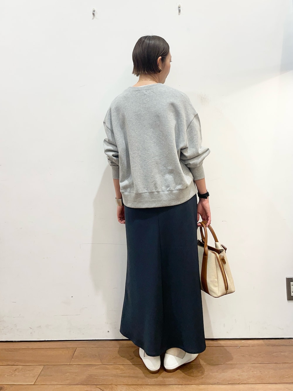 ブルー系のスカート、ホワイト系のその他シューズ、ホワイト系のハンドバッグを着用したレディースの春コーディネートの4枚目の写真