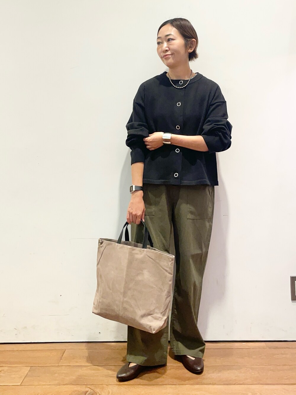 ブラック系のカーディガン/ボレロ、ブラウン系のパンプス、グレー系のバッグを着用したレディースの秋コーディネートの3枚目の写真