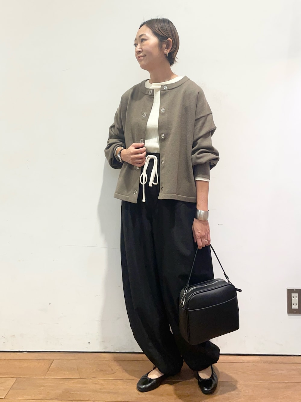 ホワイト系のTシャツ/カットソー、ブラック系のその他パンツ、ブラック系のショルダーバッグを着用したレディースの秋コーディネートの3枚目の写真