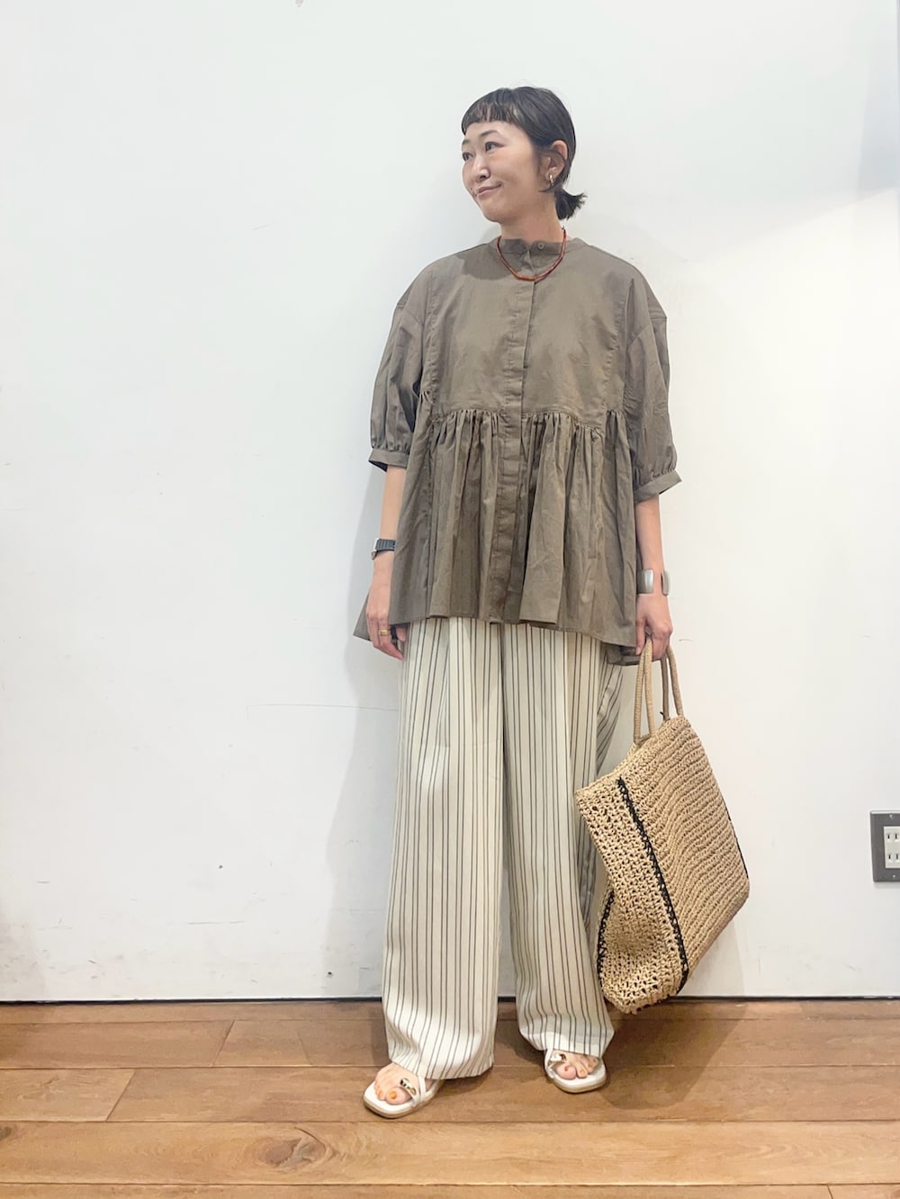 ベージュ系のトートバッグ、グレー系のサンダル、ベージュ系のその他パンツを着用したレディースの夏コーディネートの2枚目の写真