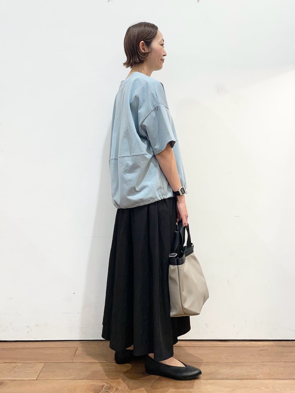 ブルー系のTシャツ/カットソー、ブラック系のパンプス、グレー系のハンドバッグを着用したレディースの春コーディネートの3枚目の写真