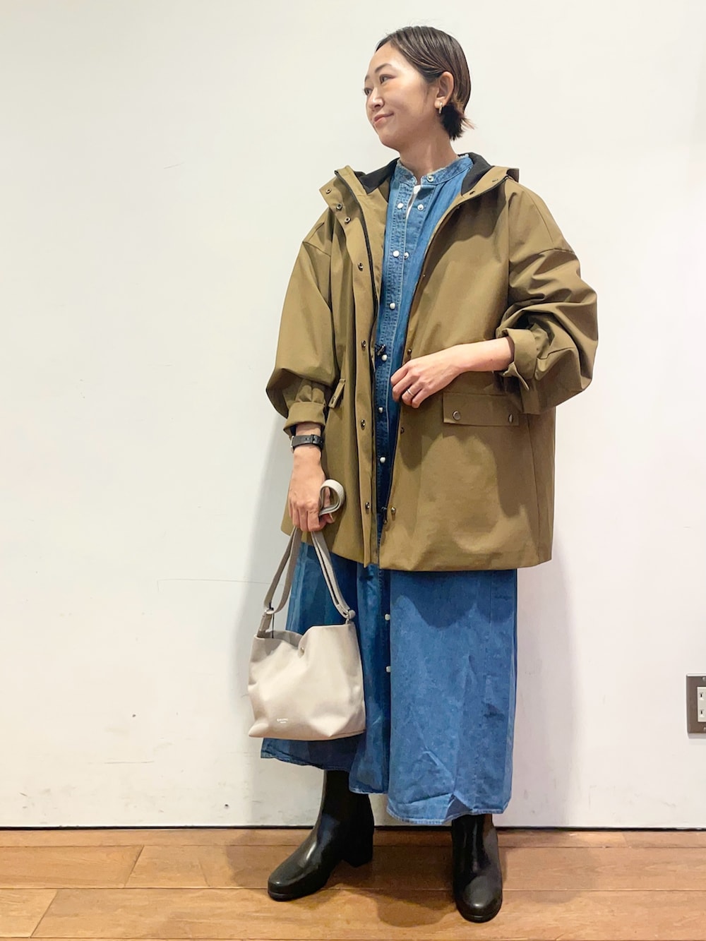 ベージュ系のその他アウター、ブルー系のワンピース、ブラック系のブーツを着用したレディースの秋コーディネートの3枚目の写真