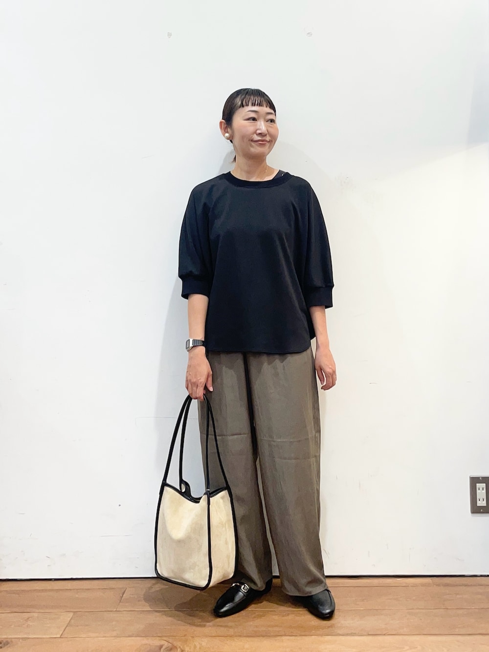 ブラック系のTシャツ/カットソー、ブラウン系のその他パンツ、ベージュ系のトートバッグを着用したレディースの秋コーディネートの2枚目の写真