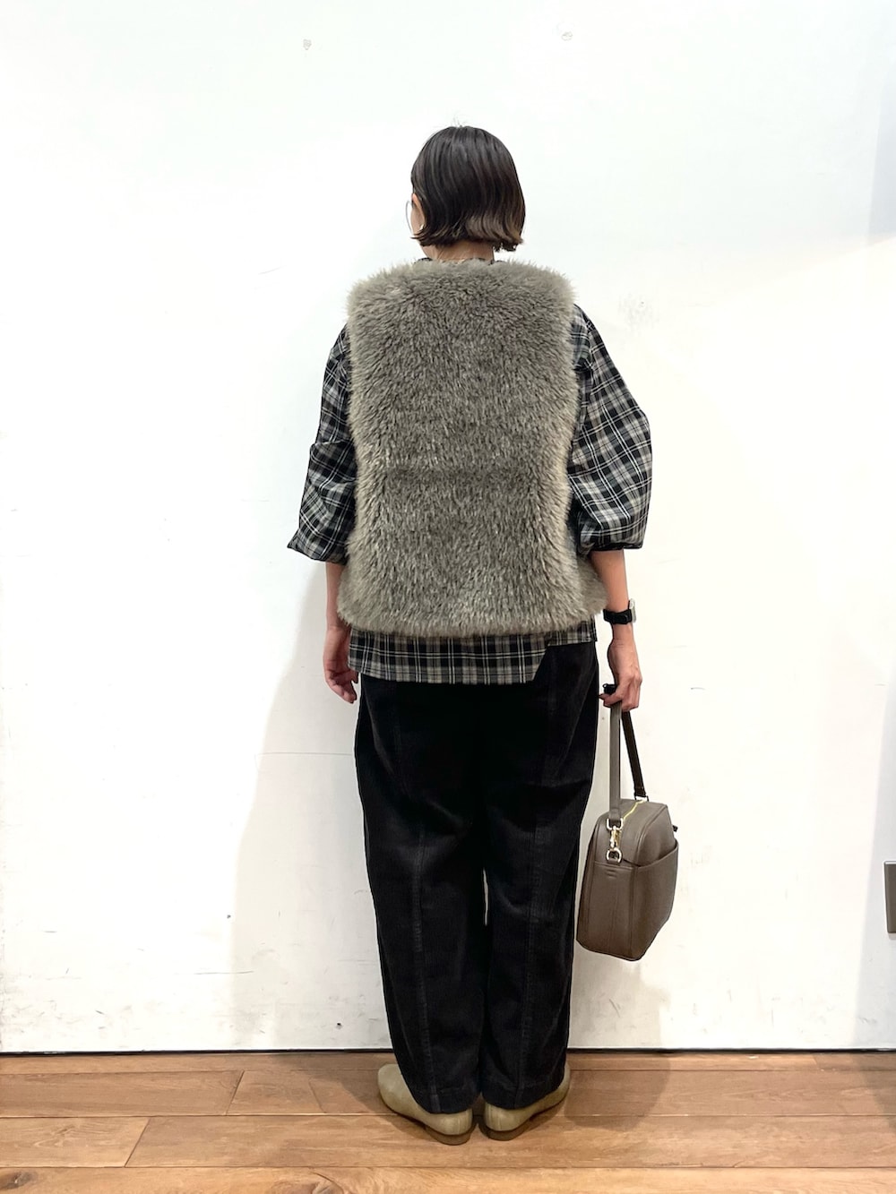 グレー系のダウンベスト、ブラック系のシャツ/ブラウス、グレー系のその他パンツを着用したレディースの秋コーディネートの5枚目の写真