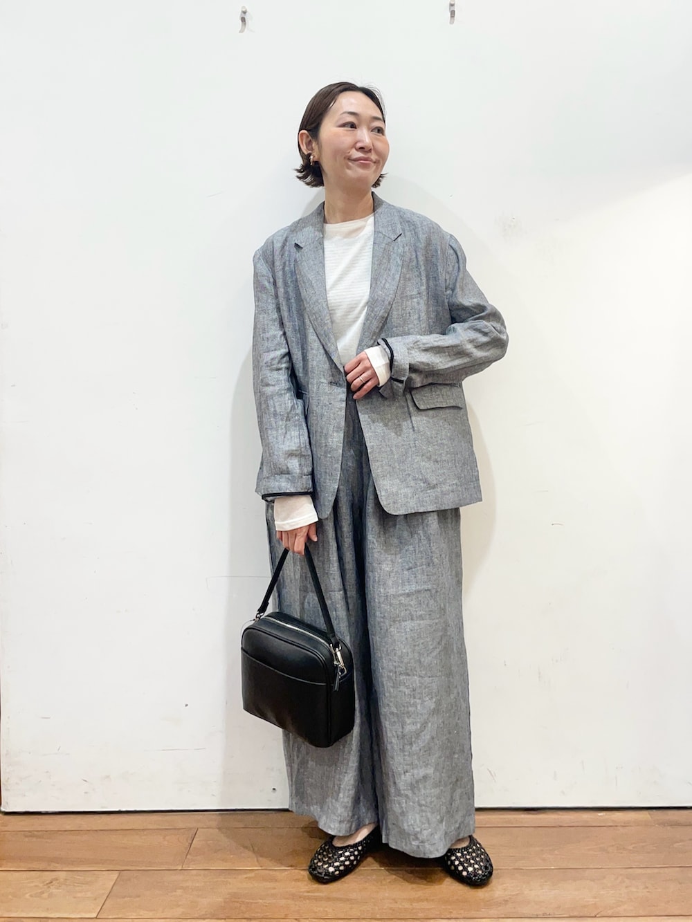 グレー系のその他アウター、ホワイト系のTシャツ/カットソー、ブラック系のサンダルを着用したレディースの春コーディネートの2枚目の写真