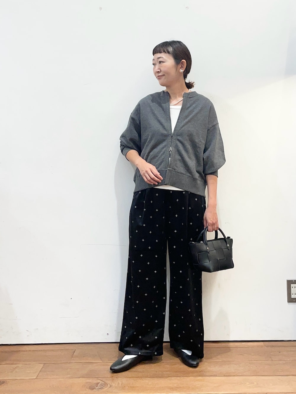 グレー系のカーディガン/ボレロ、ホワイト系のタンクトップ、ブラック系のパンプスを着用したレディースの秋コーディネートの3枚目の写真