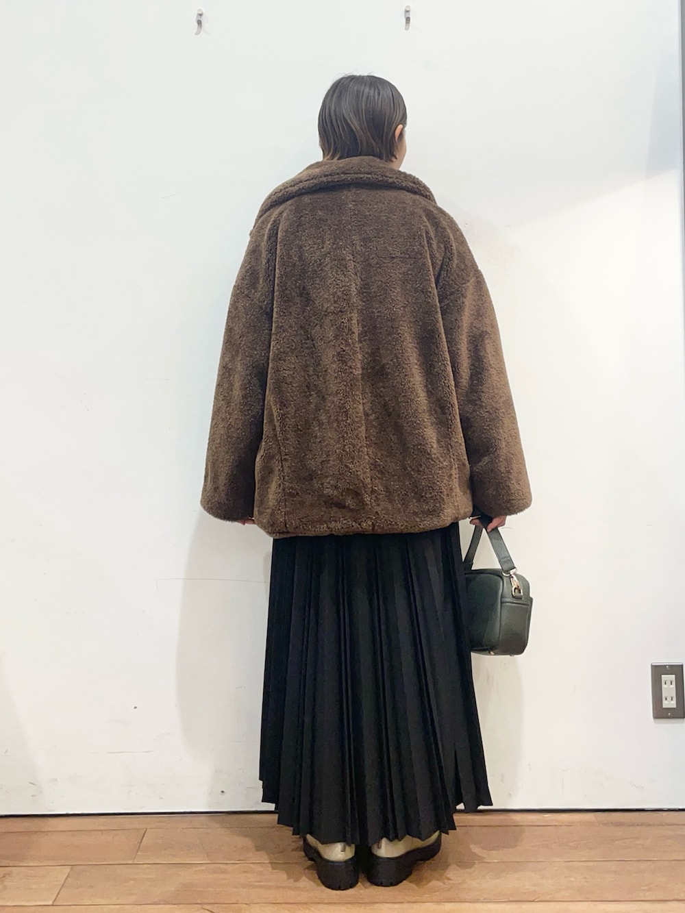 ブラウン系のその他アウター、グレー系のニット/セーター、グリーン系のショルダーバッグを着用したレディースの冬コーディネートの4枚目の写真