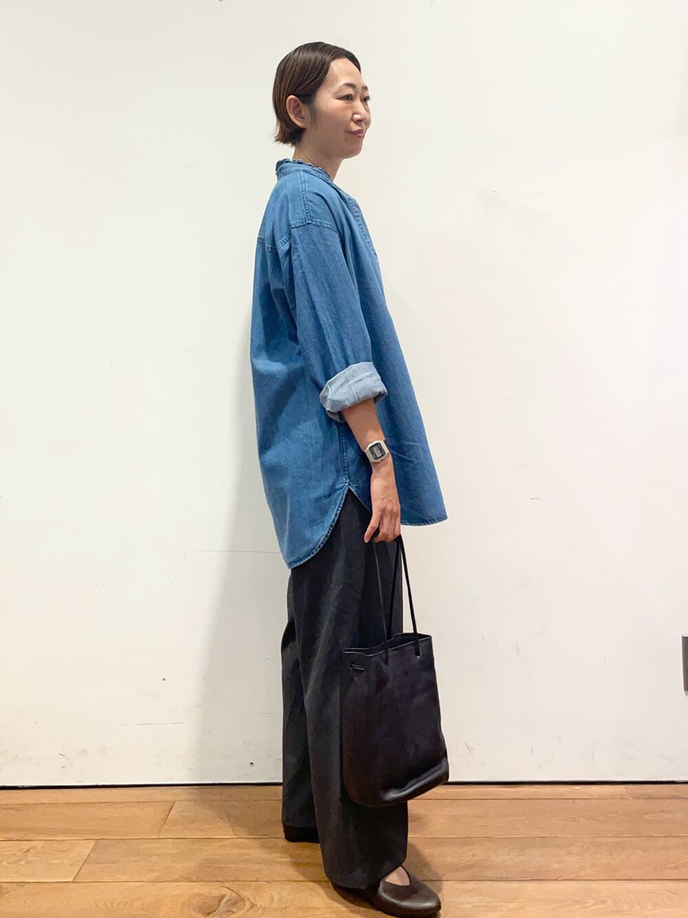 ブルー系のシャツ/ブラウス、ブラウン系のパンプス、グレー系のその他パンツを着用したレディースの秋コーディネートの4枚目の写真