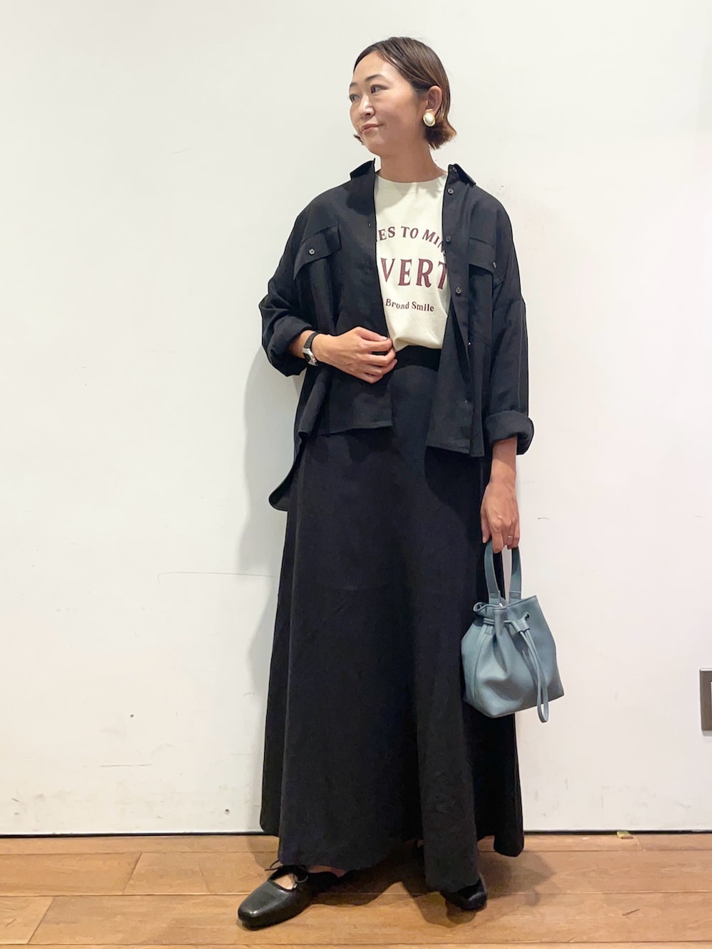 ベージュ系のTシャツ/カットソー、ブラック系のシャツ/ブラウス、ブラック系のスカートを着用したレディースの秋コーディネートの3枚目の写真