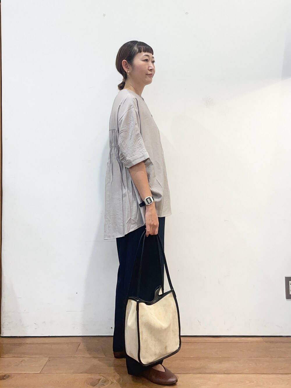 グレー系のシャツ/ブラウス、ブラウン系のパンプス、ベージュ系のトートバッグを着用したレディースの夏コーディネートの4枚目の写真