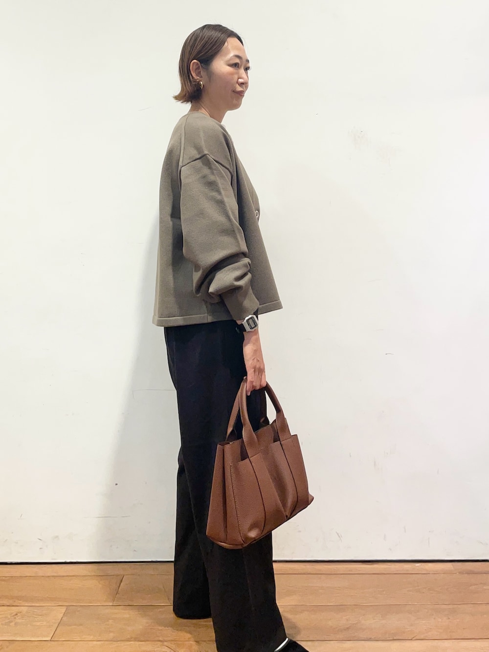 ブラウン系のカーディガン/ボレロ、ブラウン系のトートバッグ、ブラック系のその他パンツを着用したレディースの秋コーディネートの4枚目の写真