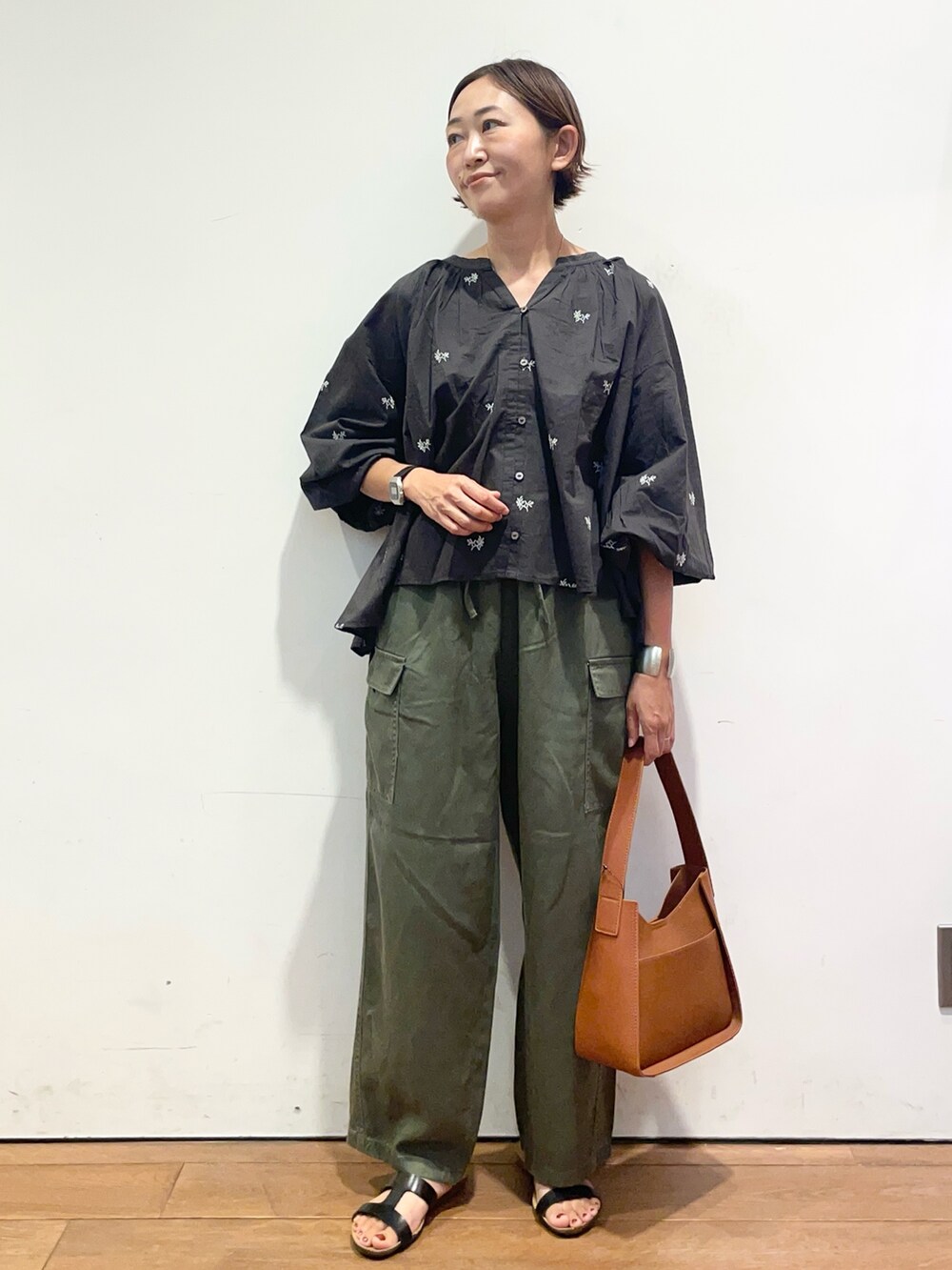 ブラック系のサンダル、グリーン系のその他パンツ、ブラウン系のハンドバッグを着用したレディースの夏コーディネートの3枚目の写真