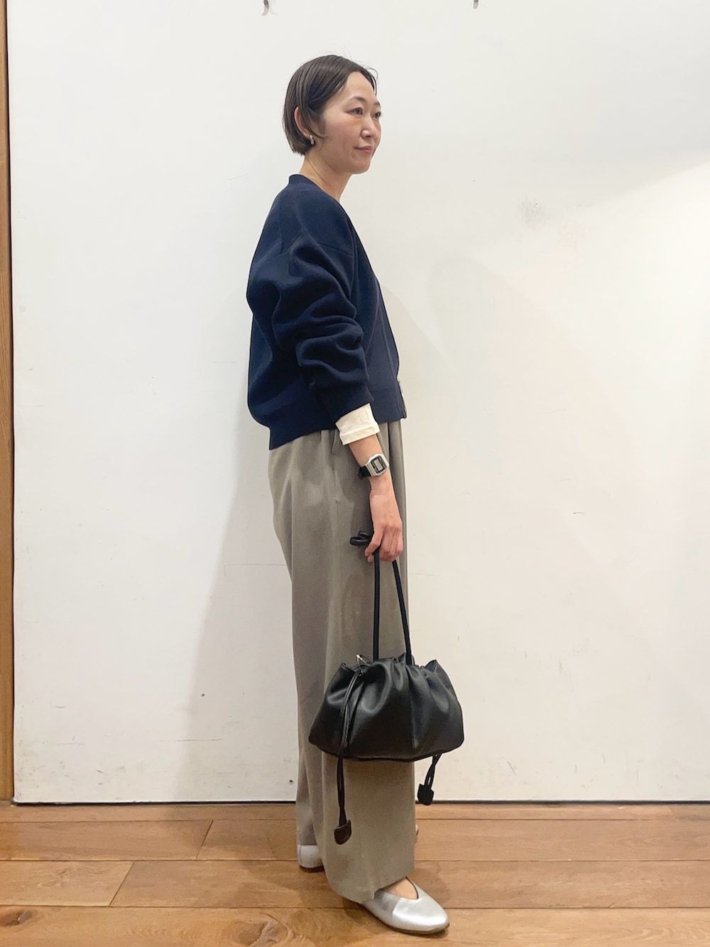 ブルー系のカーディガン/ボレロ、グレー系のその他パンツ、ブラック系のショルダーバッグを着用したレディースの春コーディネートの4枚目の写真