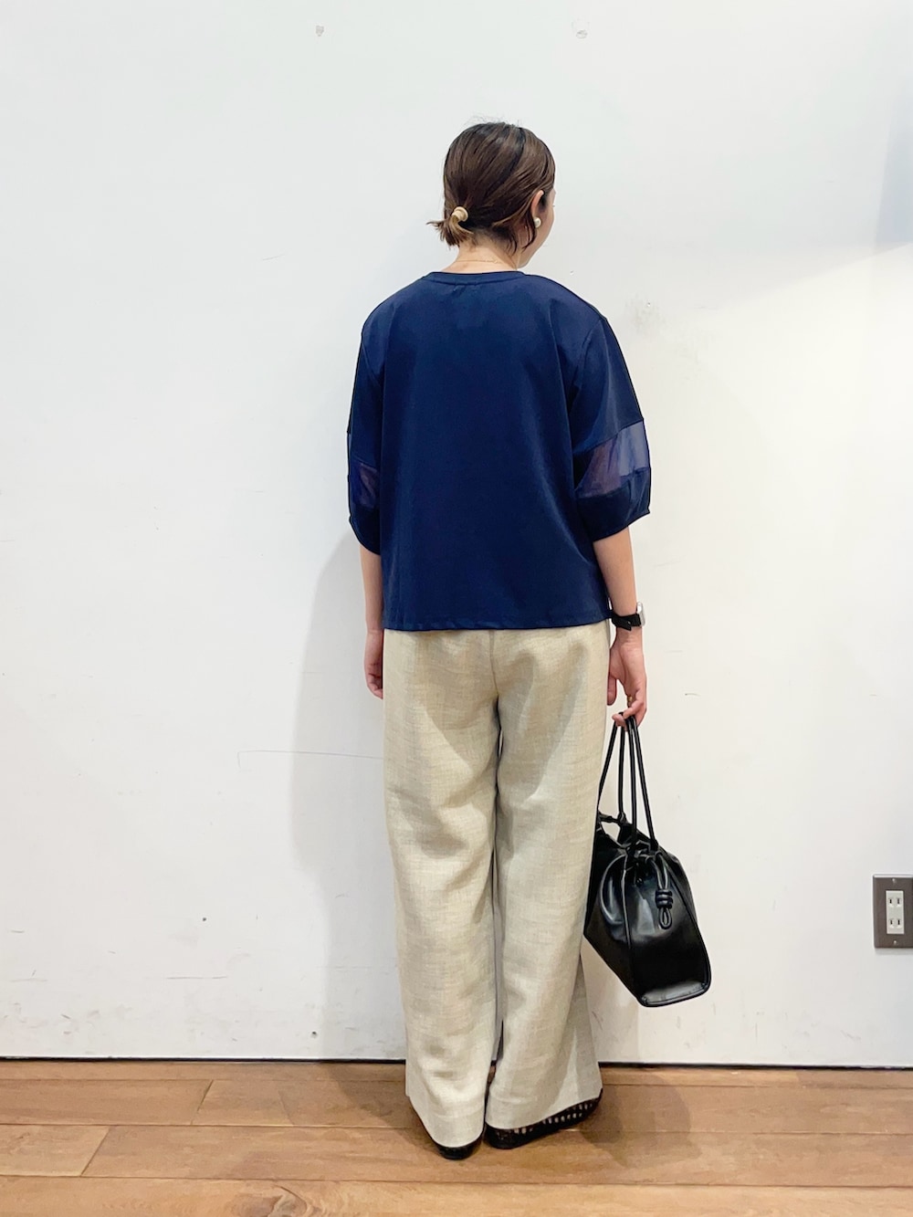 ブルー系のTシャツ/カットソー、ベージュ系のその他パンツ、ブラック系のサンダルを着用したレディースの春コーディネートの4枚目の写真