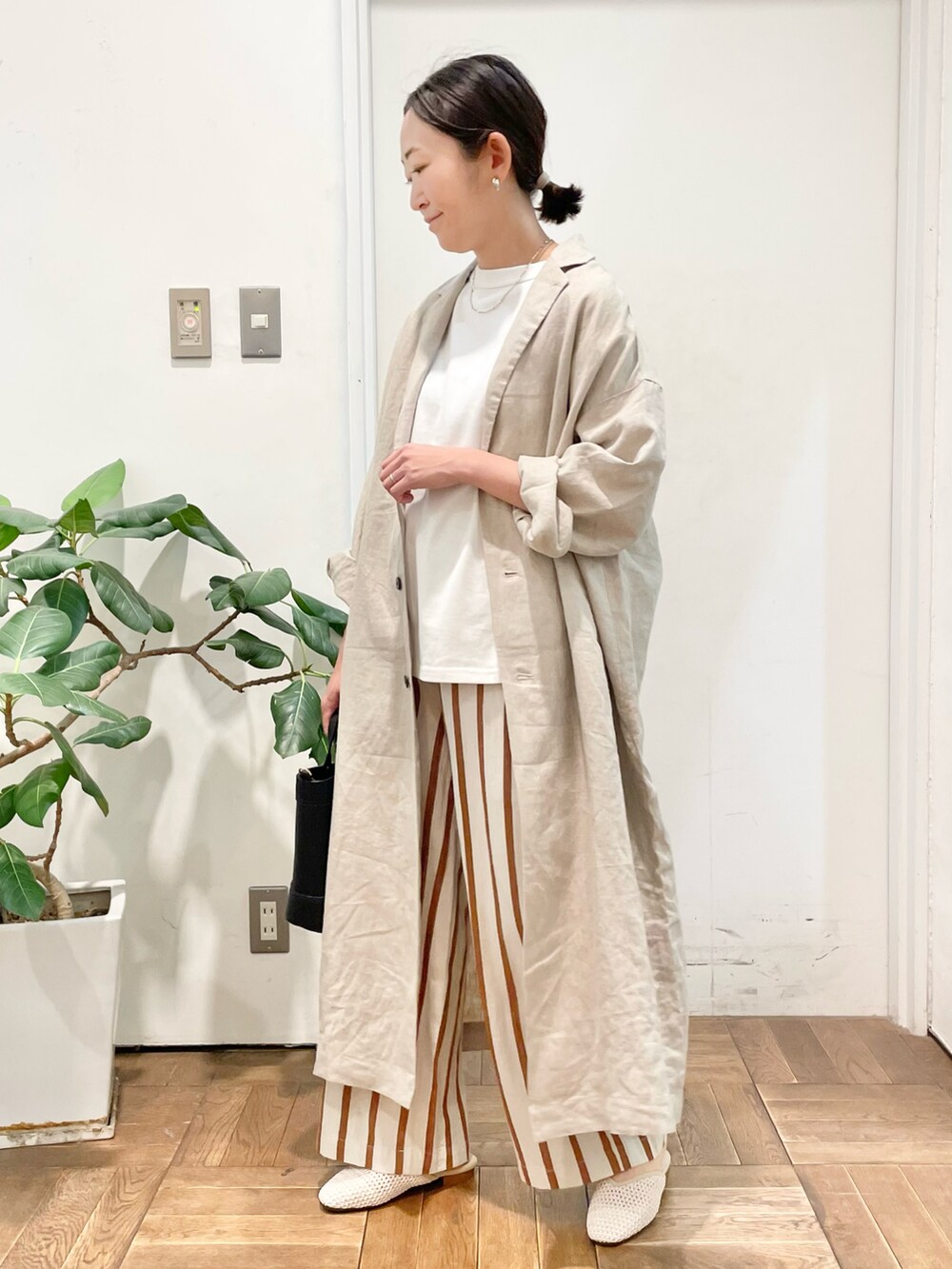 ブラック系のショルダーバッグ、ホワイト系のその他パンツ、ホワイト系のサンダルを着用したレディースの春コーディネートの2枚目の写真