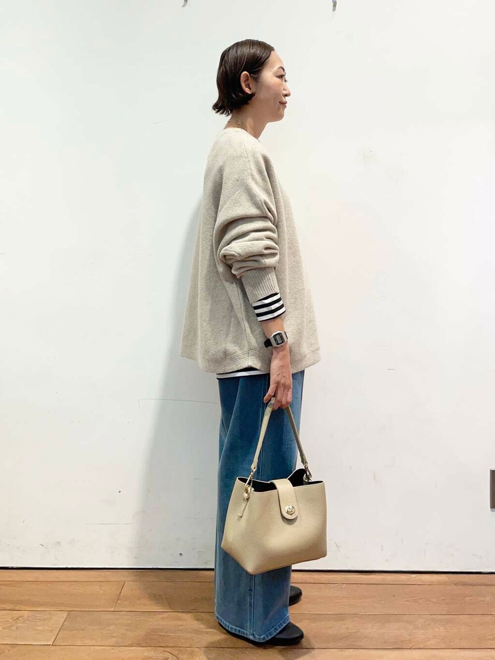 ブラック系のパンプス、ベージュ系のニット/セーター、ベージュ系のショルダーバッグを着用したレディースの秋コーディネートの4枚目の写真