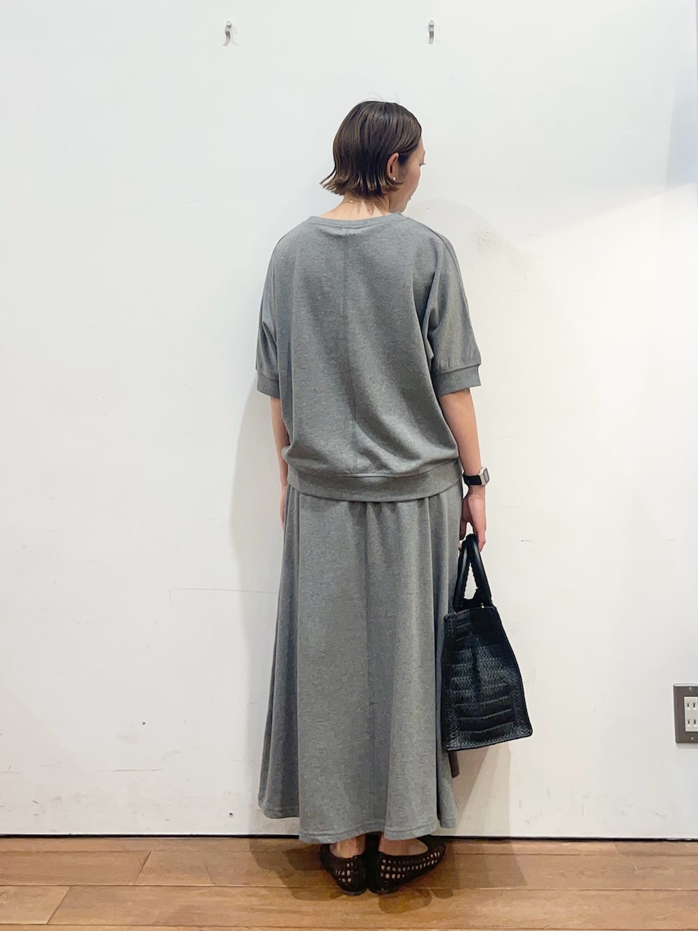 グレー系のTシャツ/カットソー、ブラウン系のサンダル、ブラック系のハンドバッグを着用したレディースの春コーディネートの4枚目の写真
