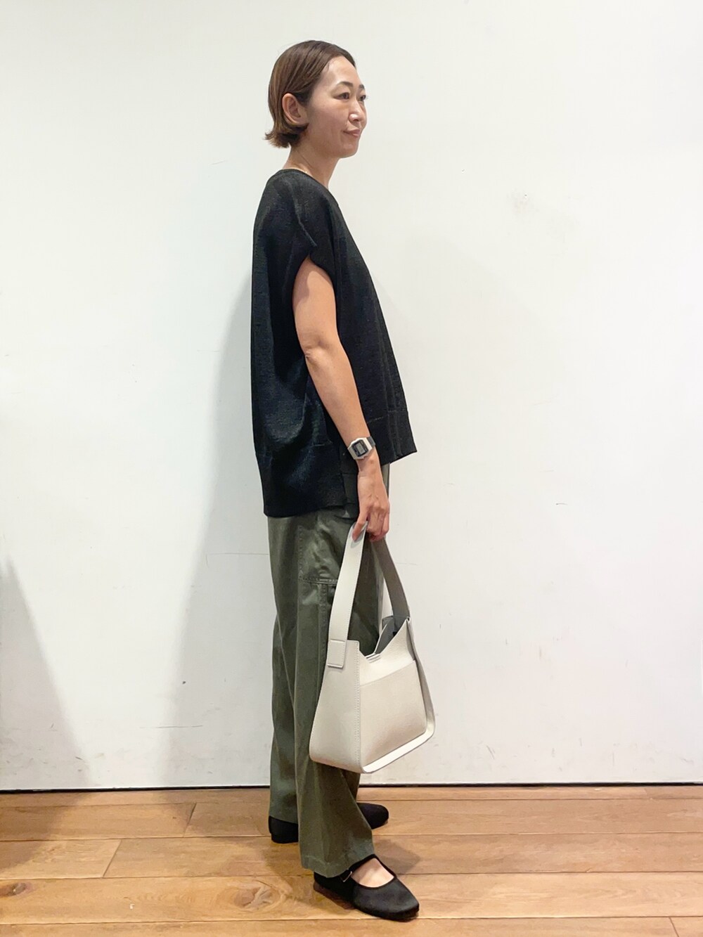 ブラック系のニット/セーター、グレー系のハンドバッグ、グリーン系のその他パンツを着用したレディースの秋コーディネートの4枚目の写真