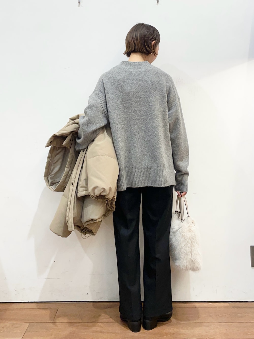 ブラウン系のダウンジャケット/コート、グレー系のニット/セーター、ブラック系のブーツを着用したレディースの冬コーディネートの8枚目の写真