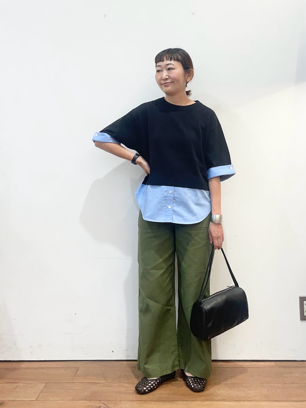 ブラック系のニット/セーター、グリーン系のその他パンツ、ブラック系のハンドバッグを着用したレディースの夏コーディネートの3枚目の写真