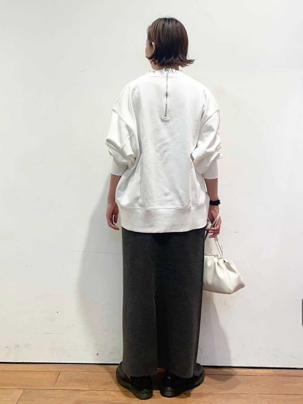 グレー系のスカート、ホワイト系のショルダーバッグ、ホワイト系のTシャツ/カットソーを着用したレディースの冬コーディネートの5枚目の写真