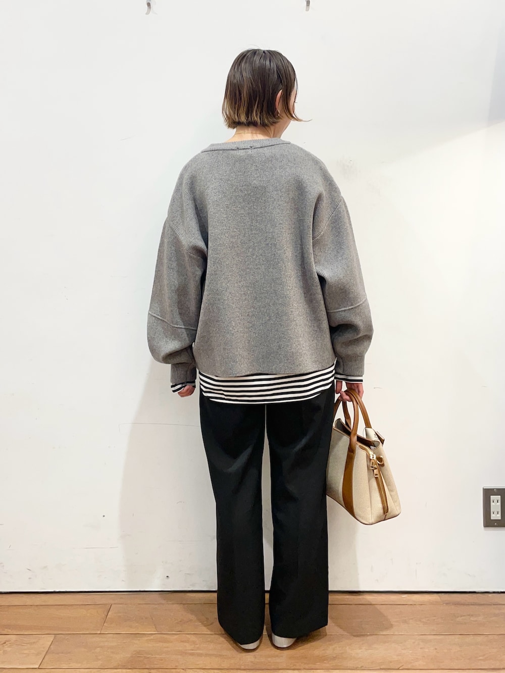 グレー系のブルゾン、ホワイト系のTシャツ/カットソー、ブラック系のその他パンツを着用したレディースの冬コーディネートの5枚目の写真