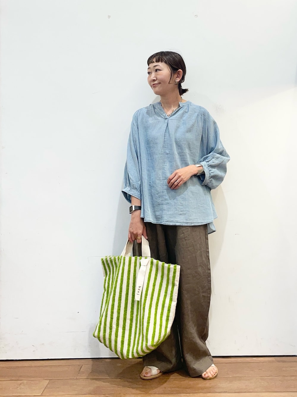 ブルー系のシャツ/ブラウス、グリーン系のトートバッグ、ブラウン系のその他パンツを着用したレディースの夏コーディネートの2枚目の写真