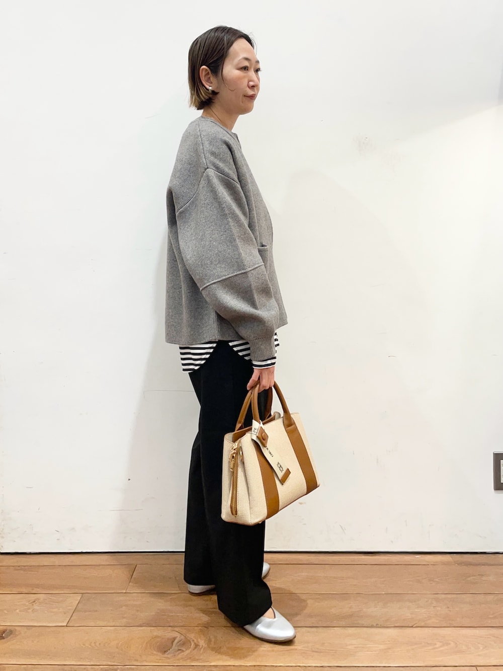 グレー系のブルゾン、ホワイト系のTシャツ/カットソー、ブラック系のその他パンツを着用したレディースの冬コーディネートの4枚目の写真