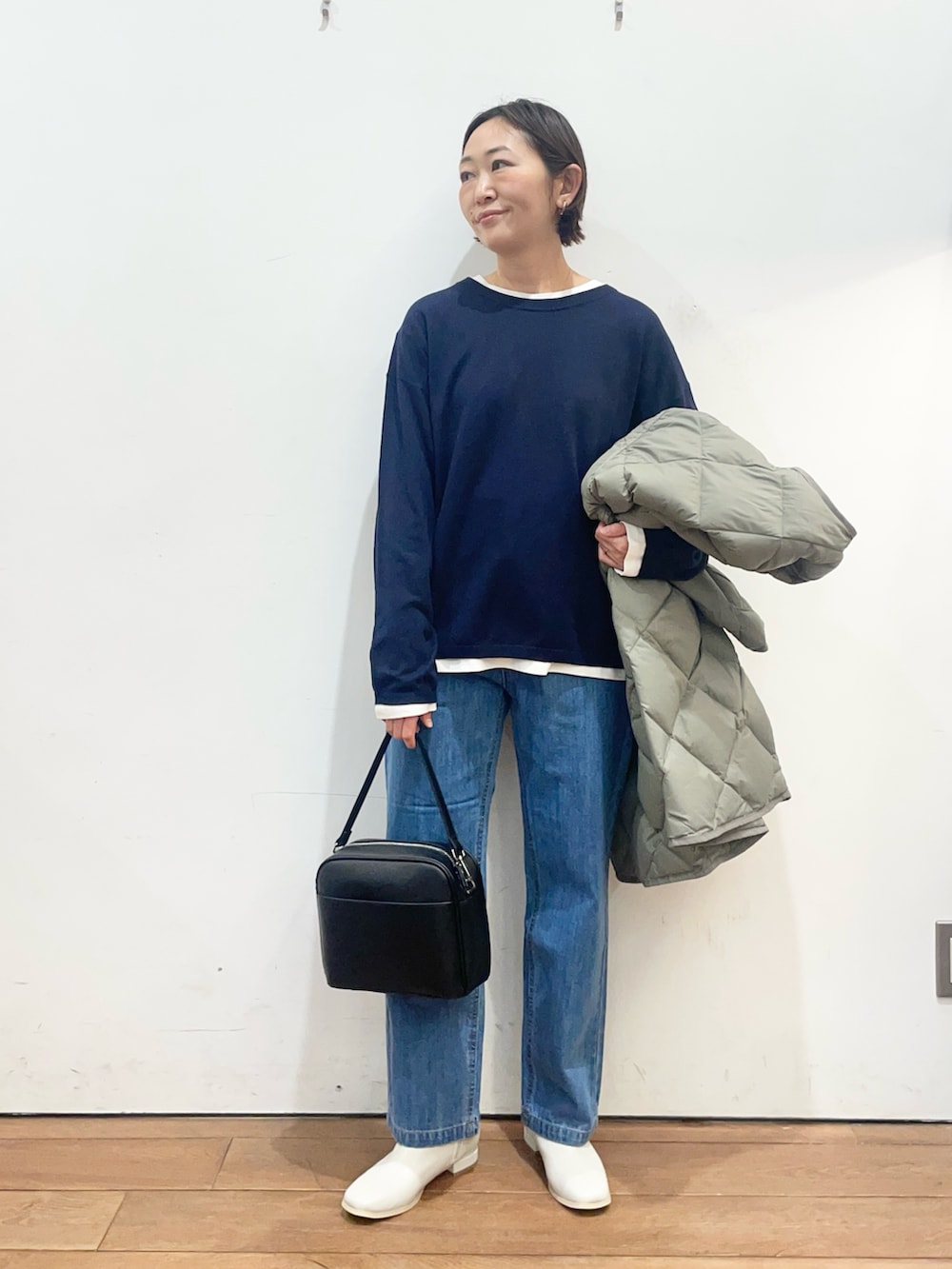 グリーン系のその他アウター、ホワイト系のブーツ、ブラック系のショルダーバッグを着用したレディースの冬コーディネートの5枚目の写真