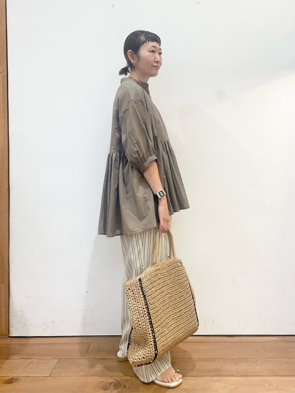 ベージュ系のトートバッグ、グレー系のサンダル、ベージュ系のその他パンツを着用したレディースの夏コーディネートの3枚目の写真
