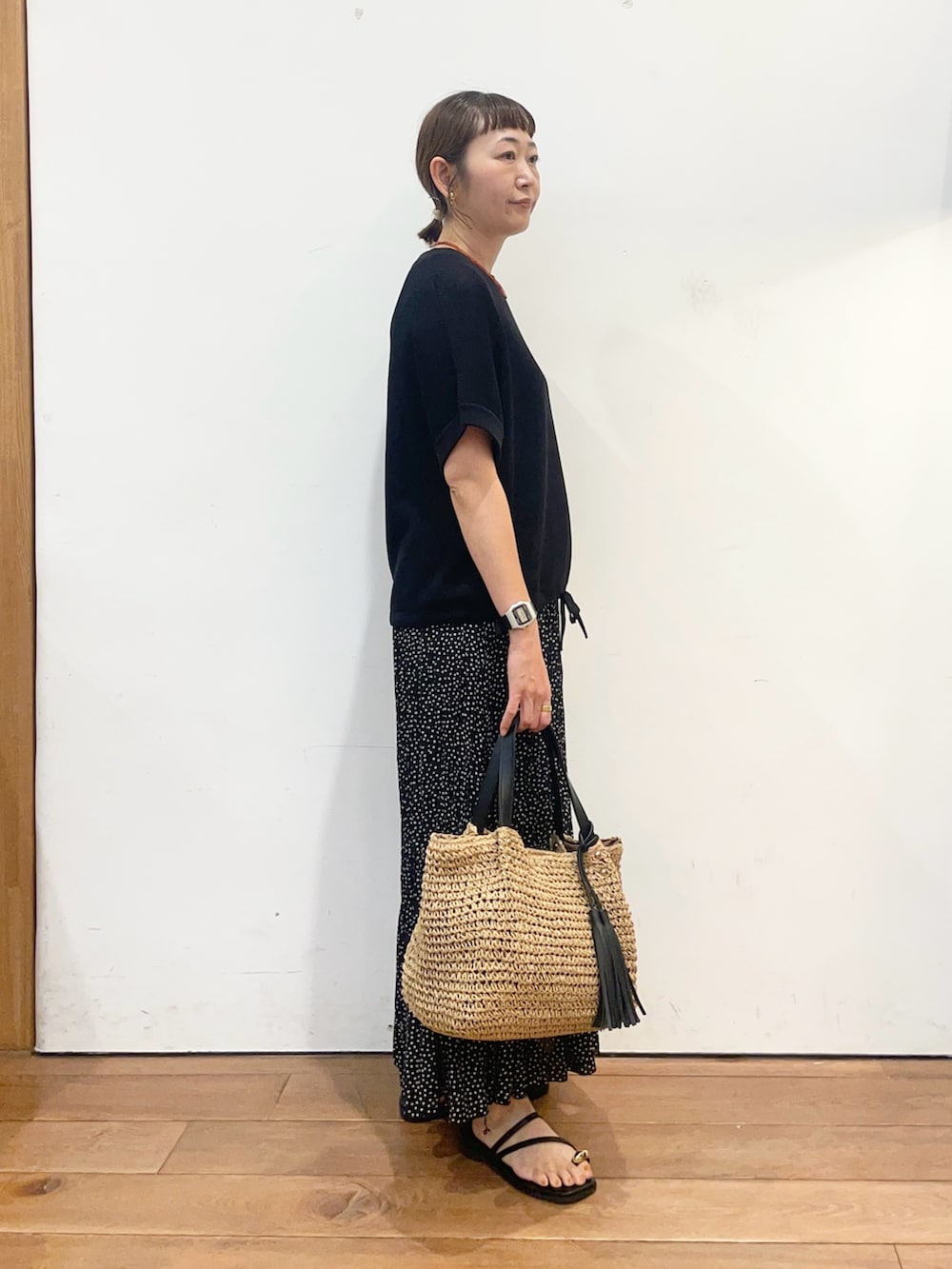 ブラック系のニット/セーター、ブラック系のスカート、ブラック系のサンダルを着用したレディースの夏コーディネートの3枚目の写真