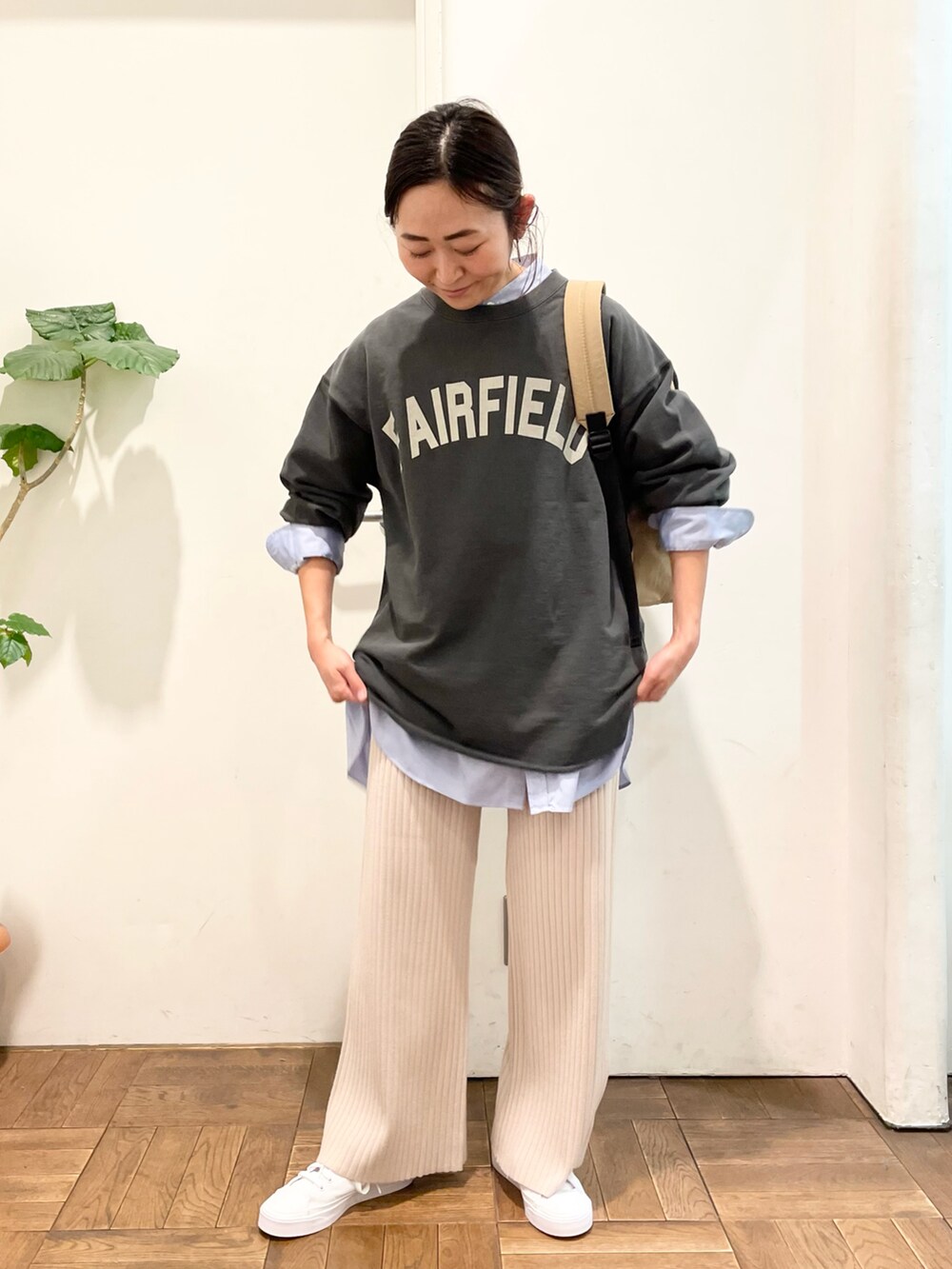 ブルー系のシャツ/ブラウス、グレー系のスウェット、ベージュ系のバックパック/リュックを着用したレディースの冬コーディネートの2枚目の写真