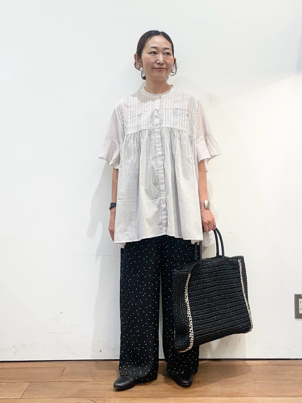 ブラック系のパンプス、ブラック系のトートバッグ、グレー系のシャツ/ブラウスを着用したレディースの春コーディネートの2枚目の写真