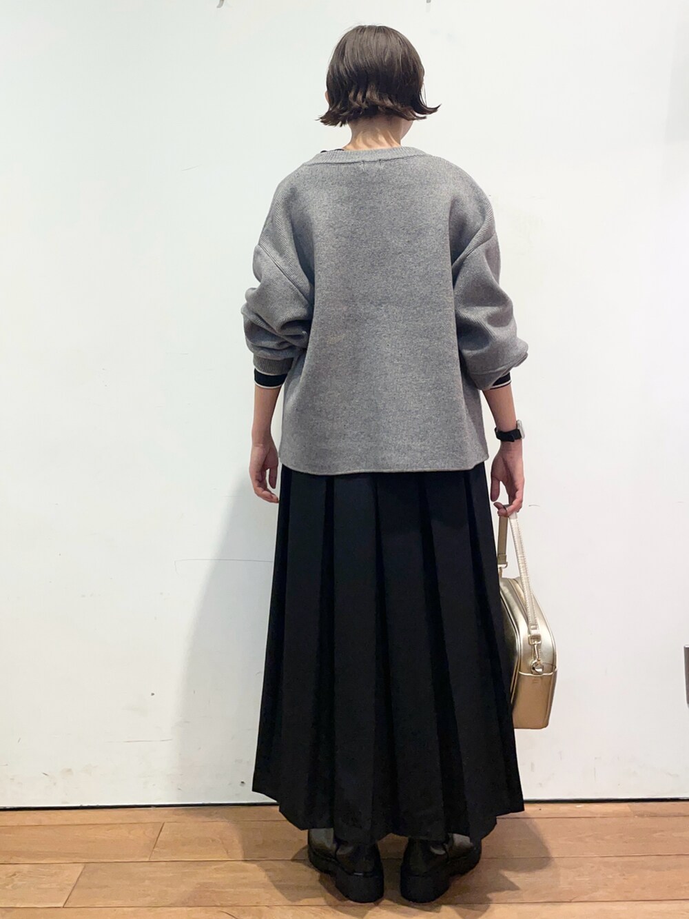 グレー系のブルゾン、ブラック系のTシャツ/カットソー、ブラック系のスカートを着用したレディースの秋コーディネートの4枚目の写真