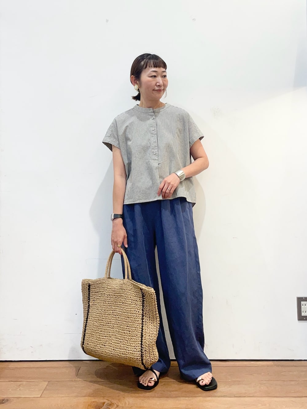 ブラック系のシャツ/ブラウス、ブルー系のその他パンツ、ベージュ系のトートバッグを着用したレディースの夏コーディネートの2枚目の写真
