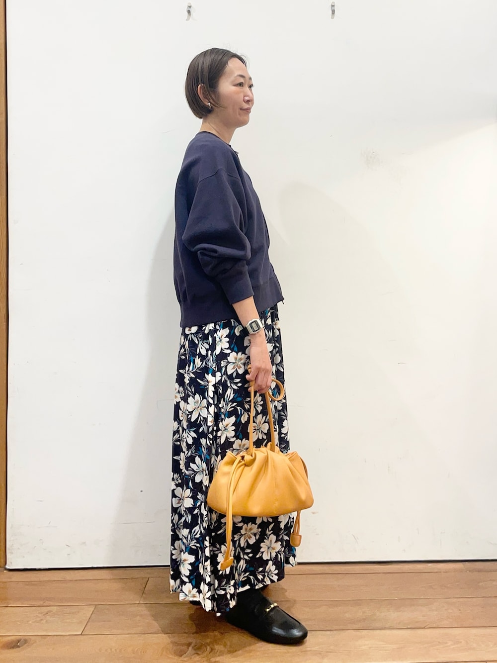 ブルー系のカーディガン/ボレロ、ブルー系のスカート、オレンジ系のショルダーバッグを着用したレディースの春コーディネートの4枚目の写真