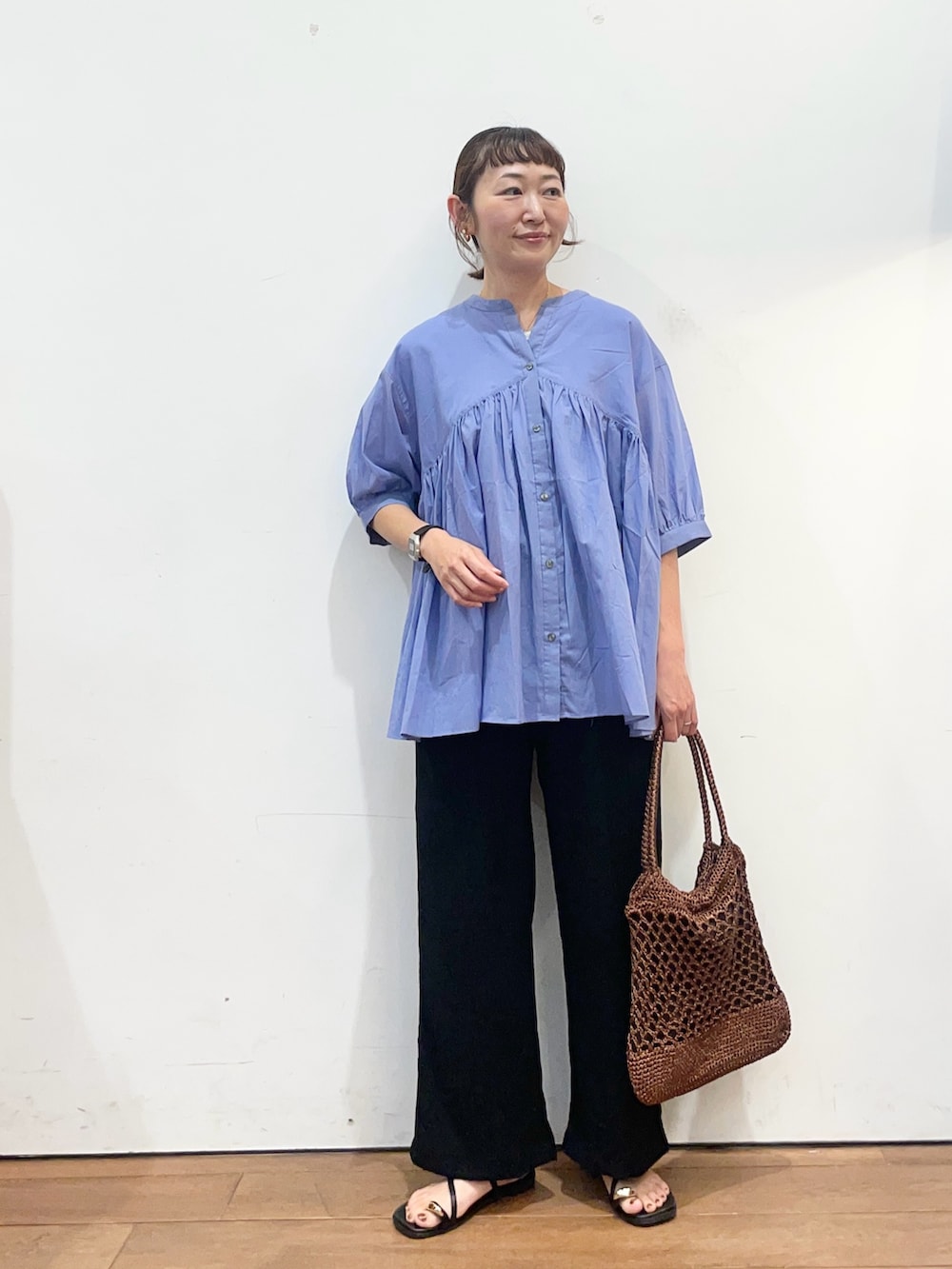 ブルー系のシャツ/ブラウス、ブラック系のその他パンツ、ブラウン系のトートバッグを着用したレディースの夏コーディネートの2枚目の写真