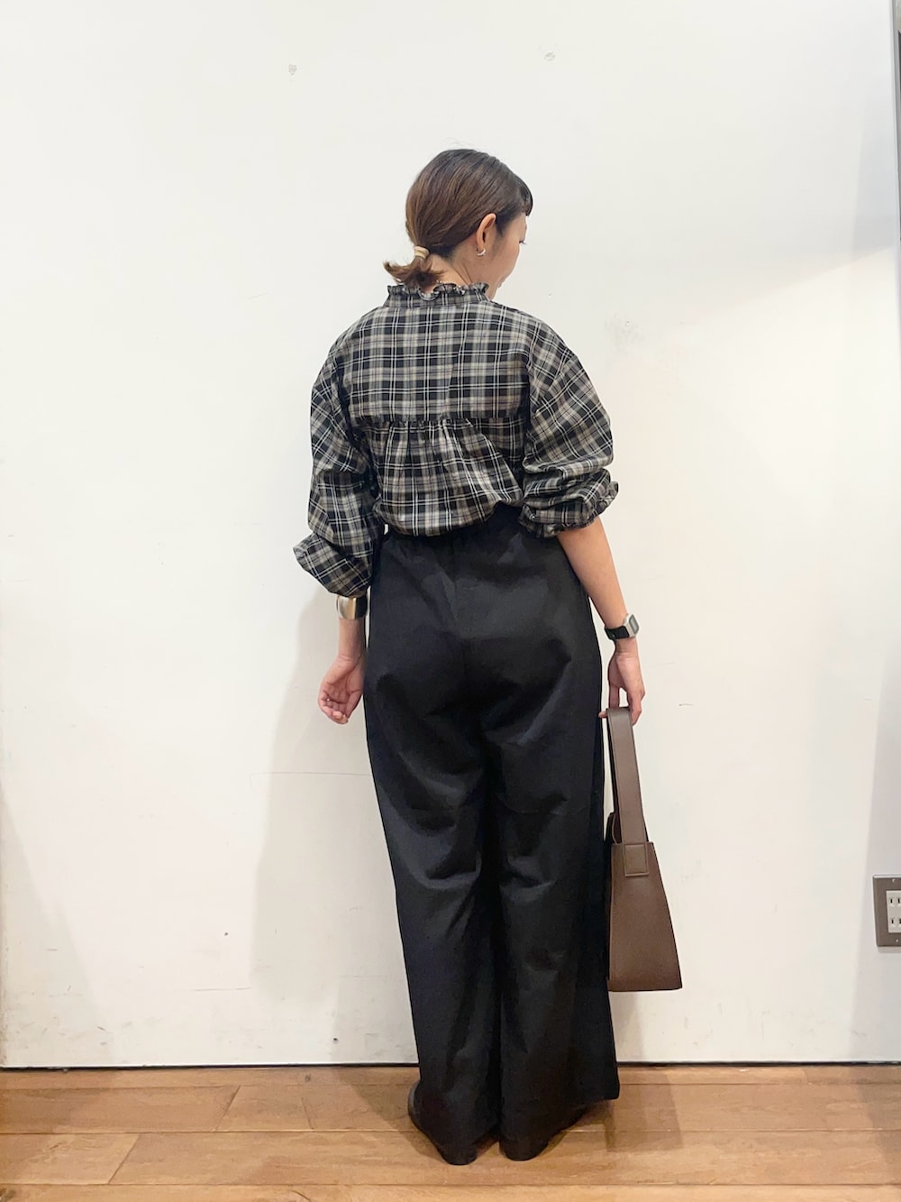 ブラック系のシャツ/ブラウス、ブラック系のその他パンツ、ブラウン系のハンドバッグを着用したレディースの秋コーディネートの5枚目の写真