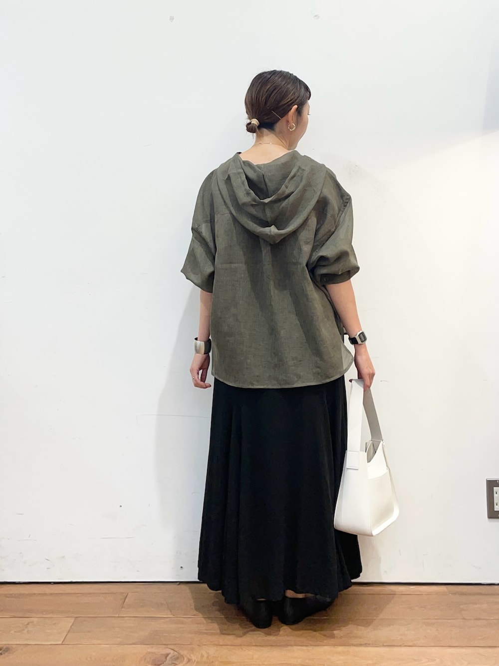 グレー系のシャツ/ブラウス、ブラック系のスカート、ホワイト系のハンドバッグを着用したレディースの秋コーディネートの4枚目の写真