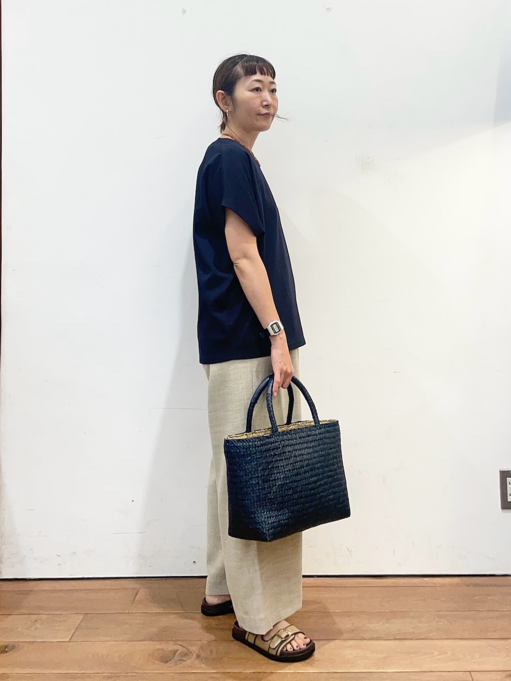 ブルー系のTシャツ/カットソー、ベージュ系のサンダル、ブルー系のトートバッグを着用したレディースの夏コーディネートの3枚目の写真