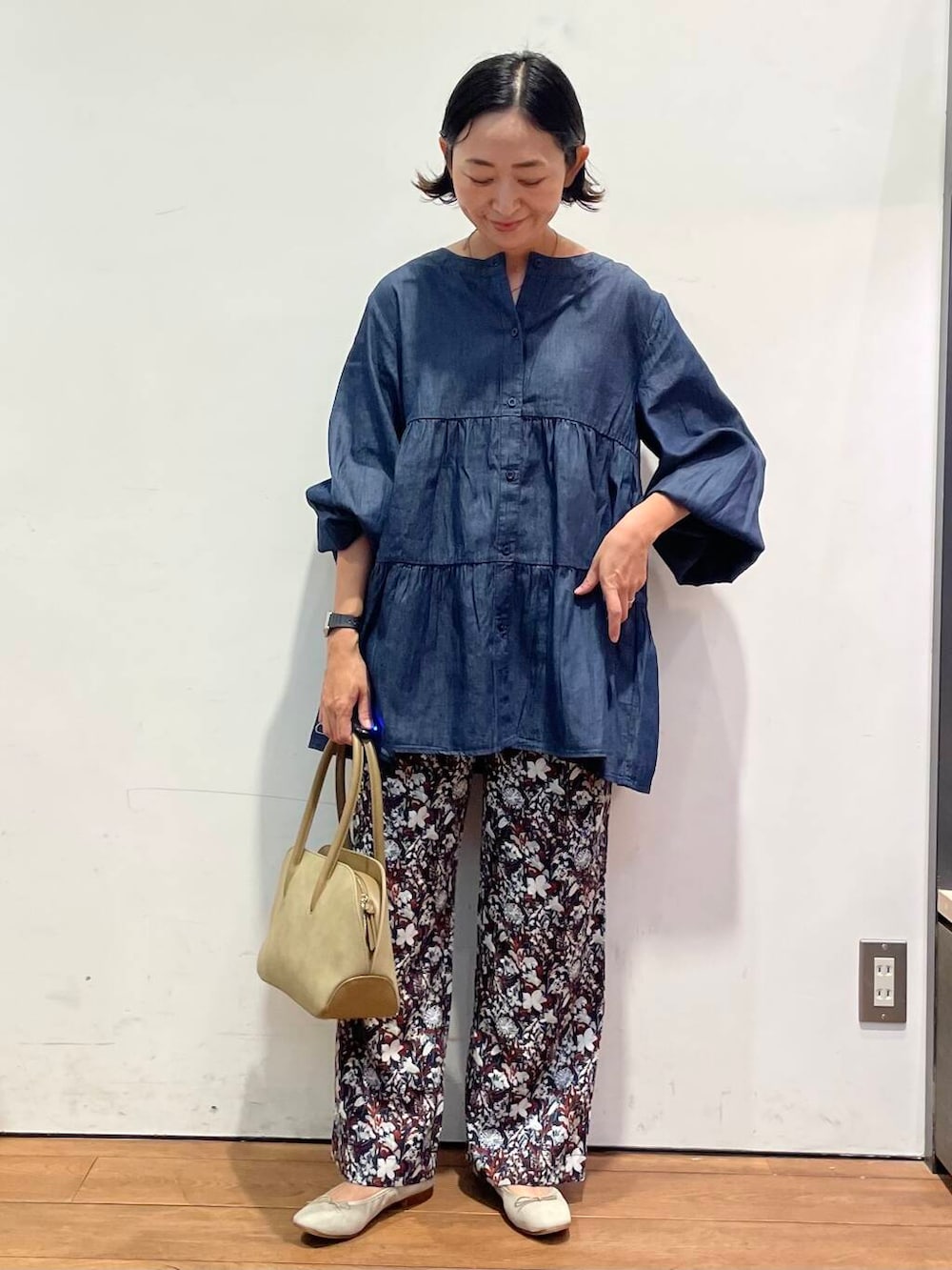 ブラウン系のバレエシューズ、レッド系のその他パンツ、ベージュ系のハンドバッグを着用したレディースの秋コーディネートの3枚目の写真