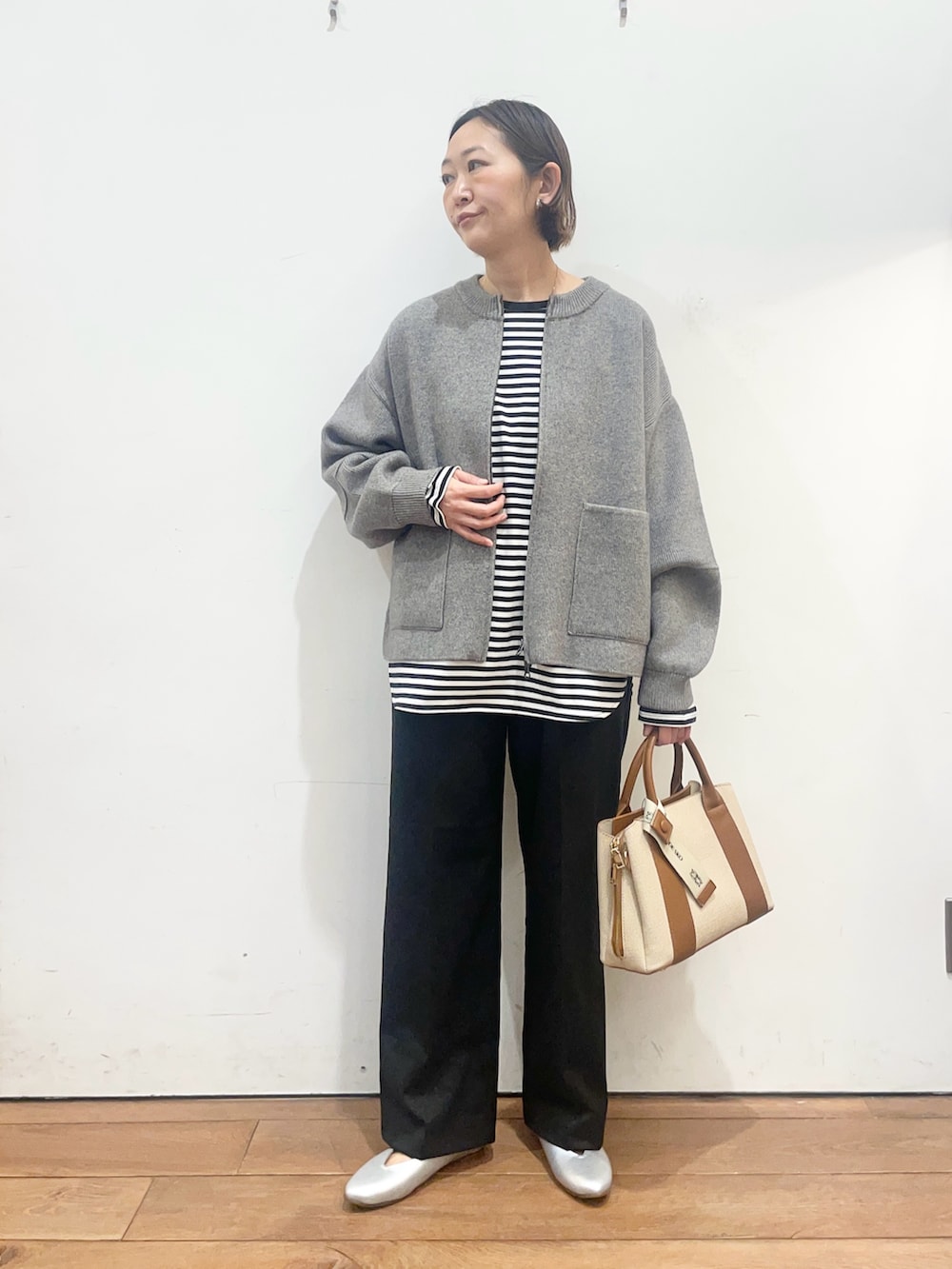 グレー系のブルゾン、ホワイト系のTシャツ/カットソー、ブラック系のその他パンツを着用したレディースの冬コーディネートの3枚目の写真