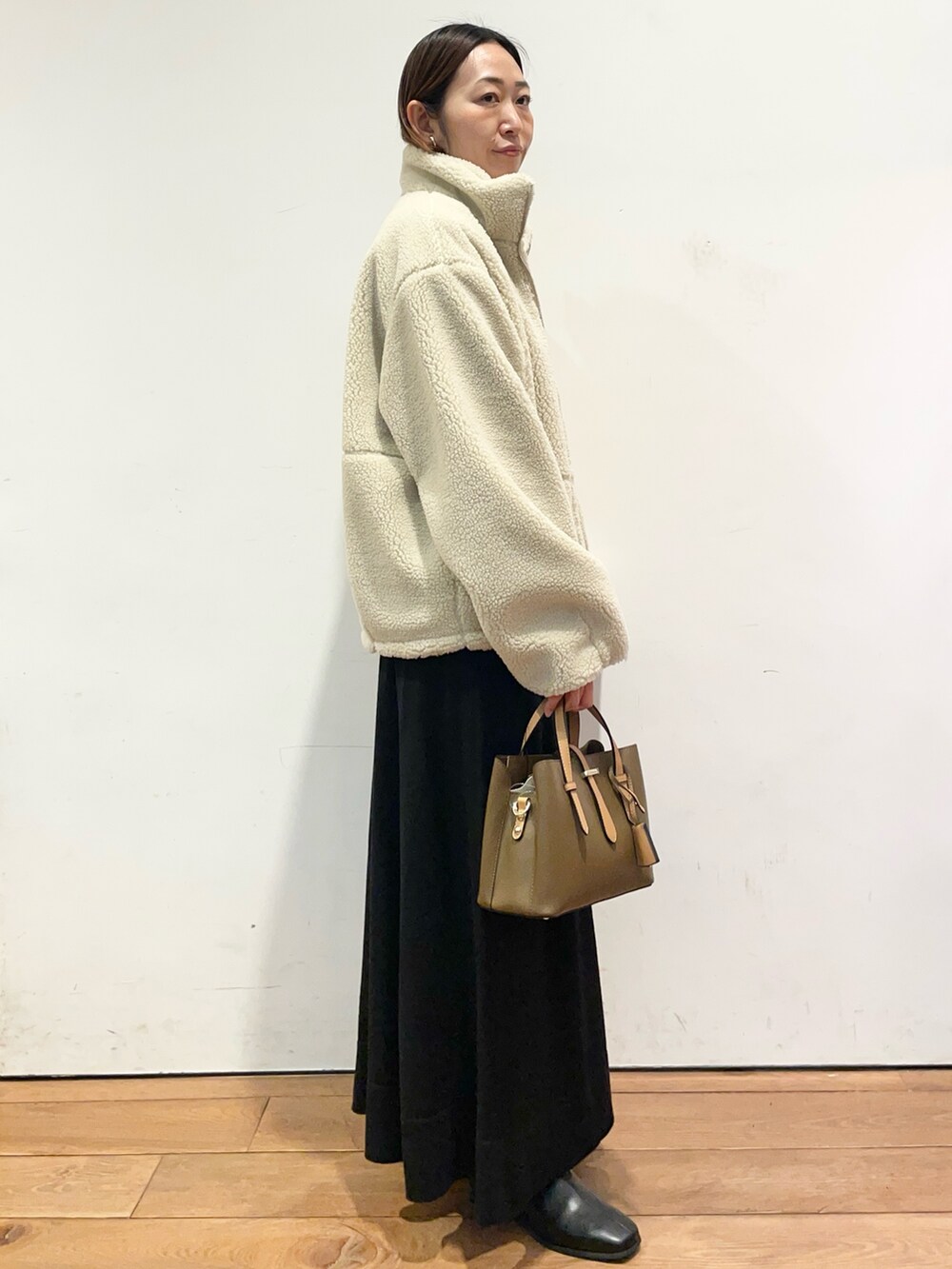 ホワイト系のその他アウター、ブラウン系のハンドバッグ、ブラック系のワンピースを着用したレディースの冬コーディネートの4枚目の写真