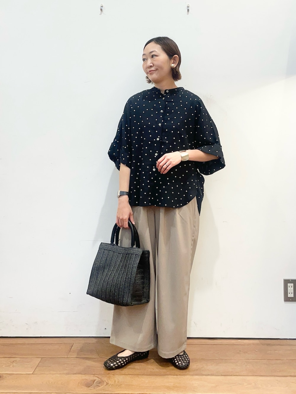 ブラック系のシャツ/ブラウス、ブラック系のサンダル、ブラック系のハンドバッグを着用したレディースの春コーディネートの3枚目の写真