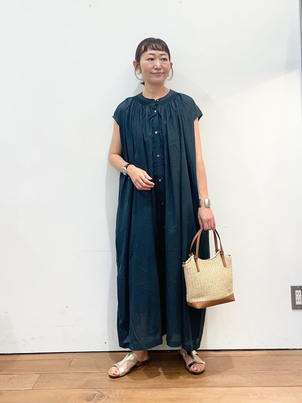 グリーン系のワンピース、イエロー系のショルダーバッグ、ゴールド系のサンダルを着用したレディースの夏コーディネートの3枚目の写真