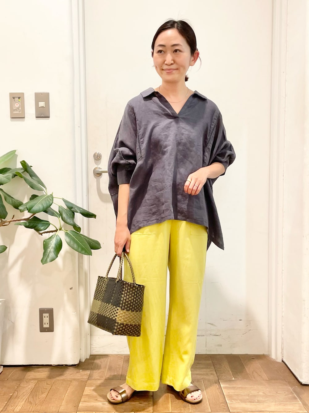 グレー系のシャツ/ブラウス、イエロー系のその他パンツ、ブラック系のトートバッグを着用したレディースの春コーディネートの2枚目の写真