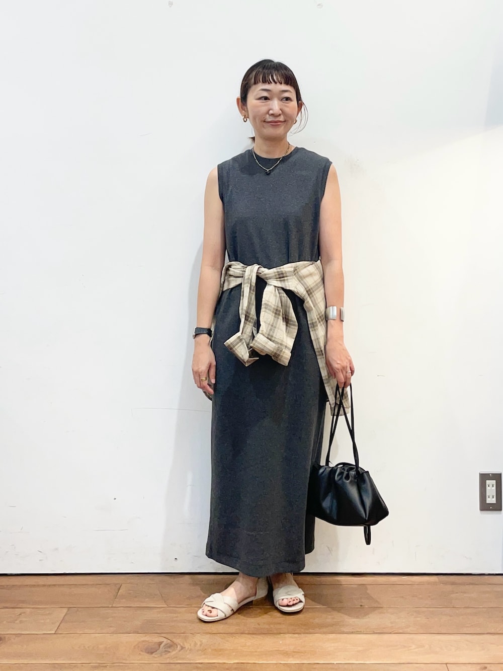 グレー系のワンピース、ベージュ系のシャツ/ブラウス、ブラック系のショルダーバッグを着用したレディースの夏コーディネートの2枚目の写真
