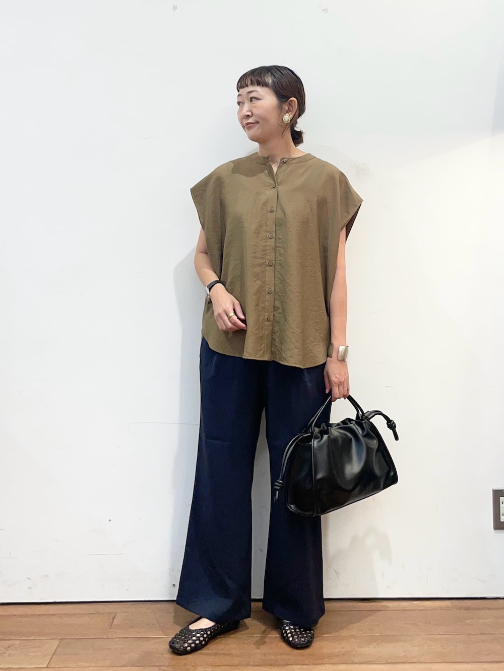 ベージュ系のシャツ/ブラウス、ブラック系のトートバッグ、ブルー系のその他パンツを着用したレディースの夏コーディネートの2枚目の写真
