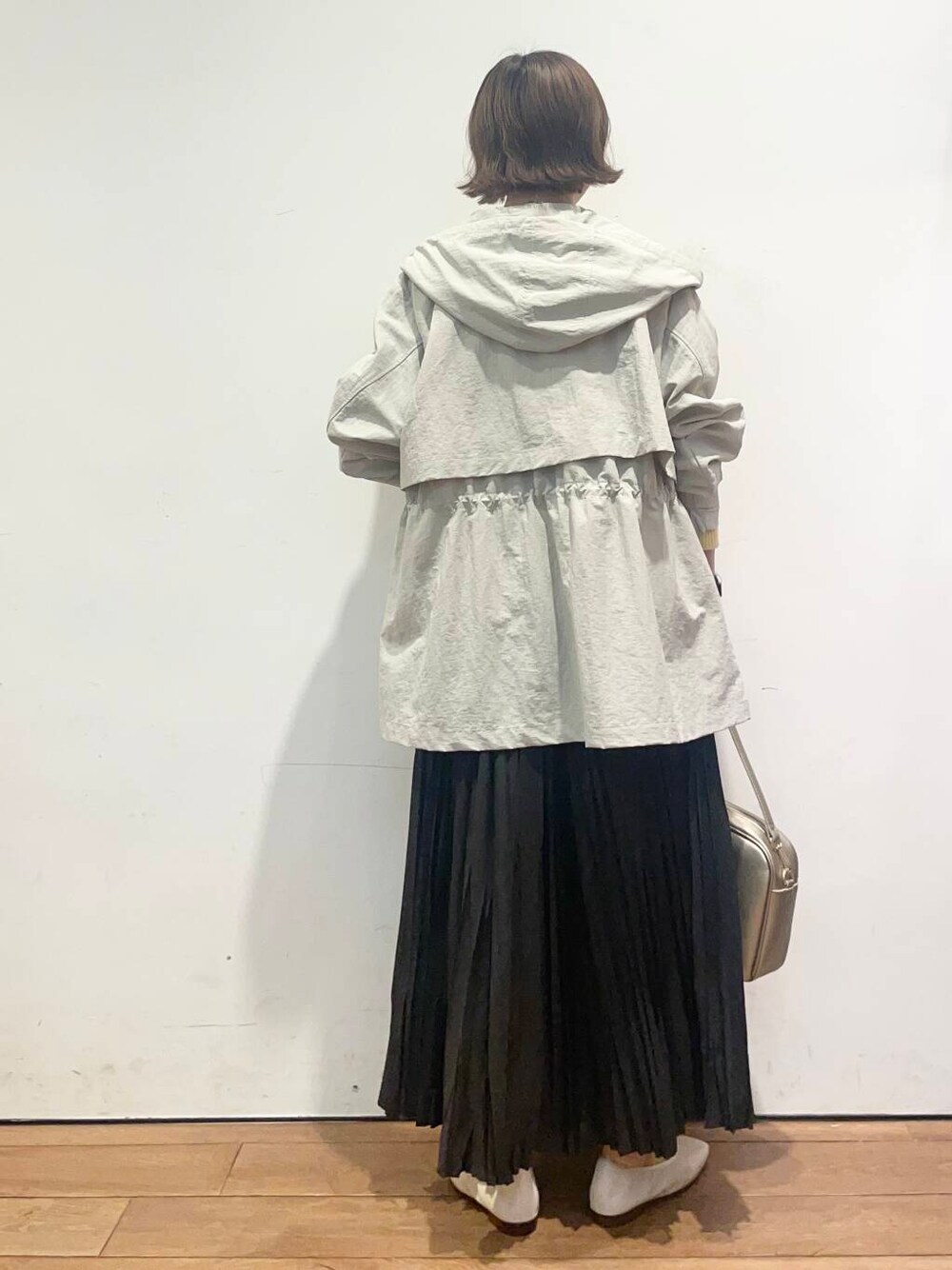 ゴールド系のショルダーバッグ、ブラック系のスカート、ホワイト系のバレエシューズを着用したレディースの春コーディネートの4枚目の写真