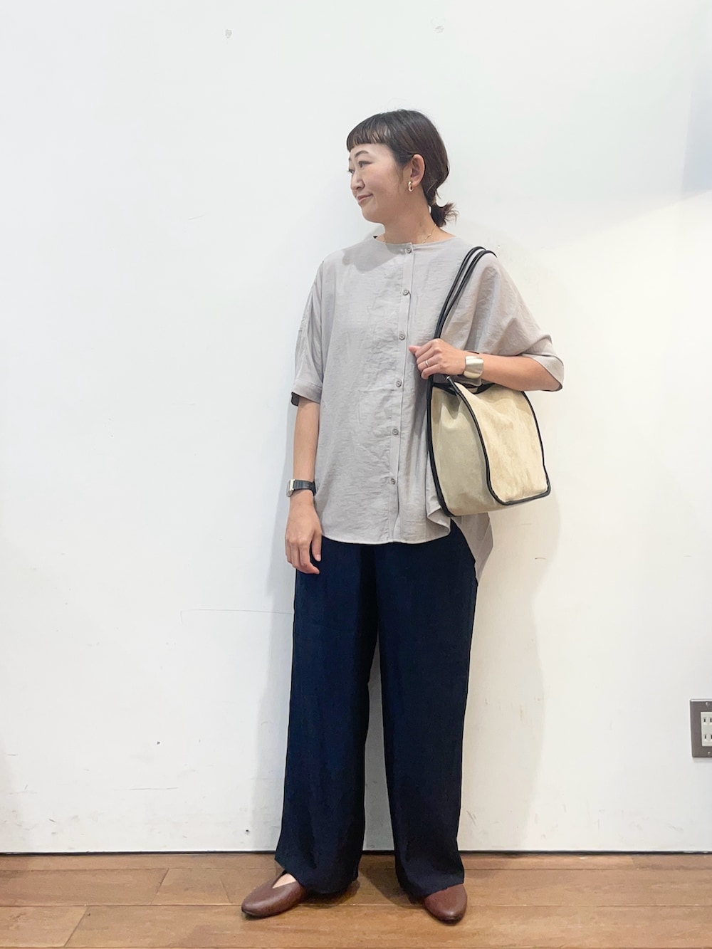 グレー系のシャツ/ブラウス、ブラウン系のパンプス、ベージュ系のトートバッグを着用したレディースの夏コーディネートの3枚目の写真